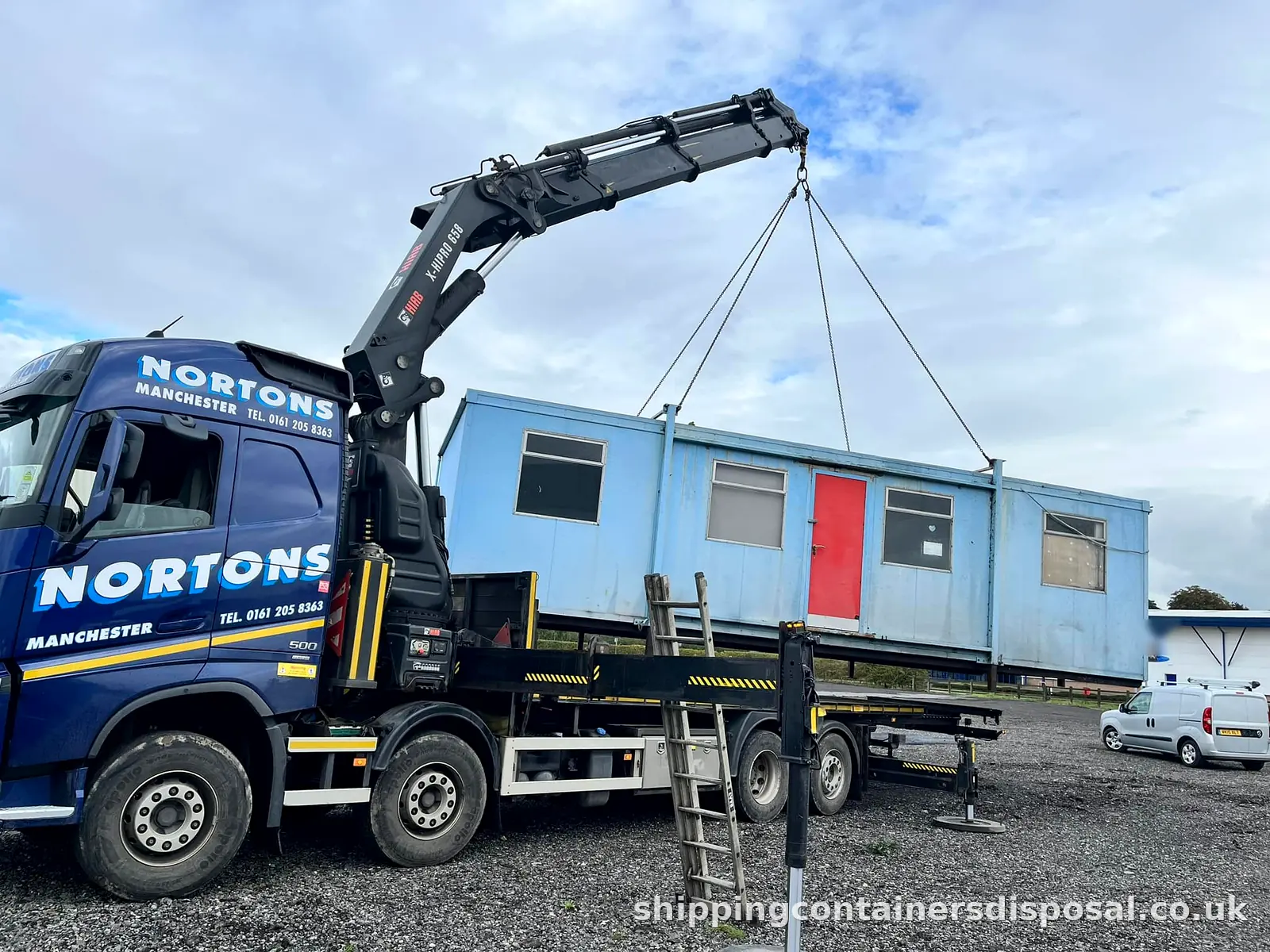 HIAB lorry lifting a blue portable cabin onto its bed HIAB lorry lifting a blue portable cabin onto its bed